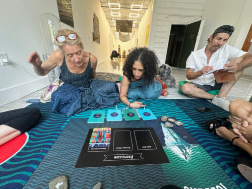Five people play The Iceberg on the floor of a gallery