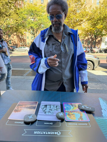 A man looks down at the cards and smiles