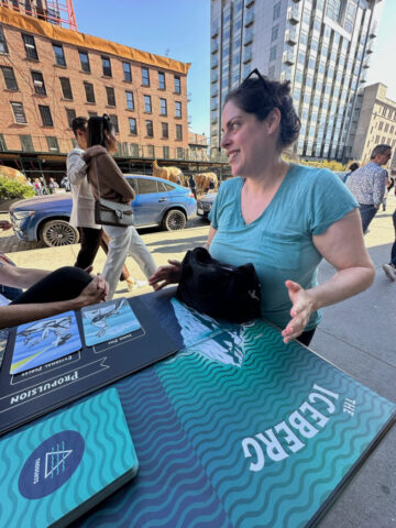 A woman smiles while discussing The Iceberg